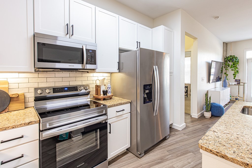 A modern kitchen with stainless steel appliances and white cabinets.