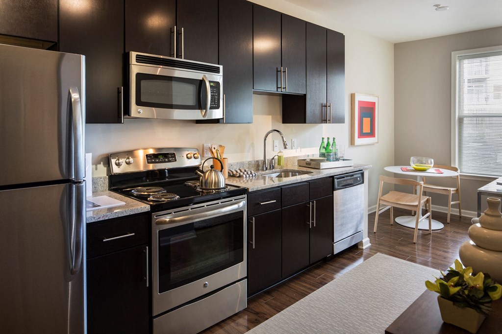A kitchen with brown cabinets and steel appliances.