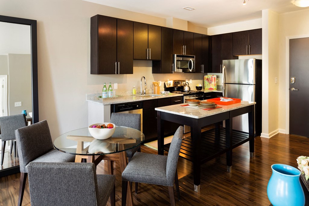 A kitchen with an island and table in front.