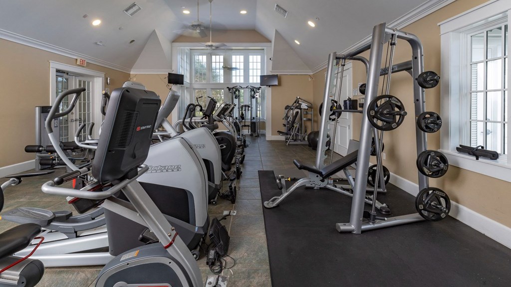A gym with treadmills, elliptical machines, and weightlifting equipment.