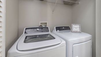 A washing machine and dryer are placed next to each other in a small room.