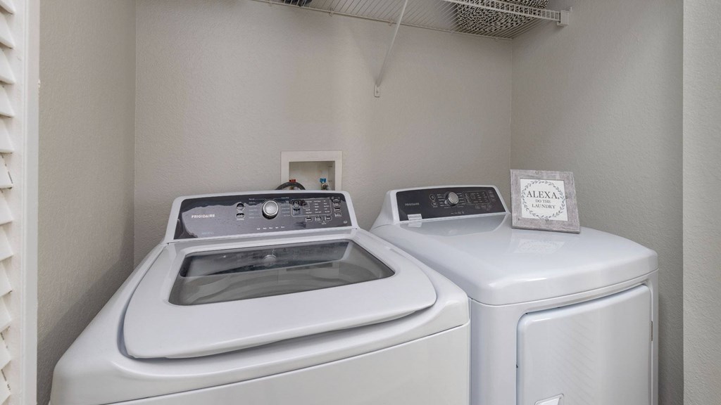 A washing machine and dryer are placed next to each other in a small room.
