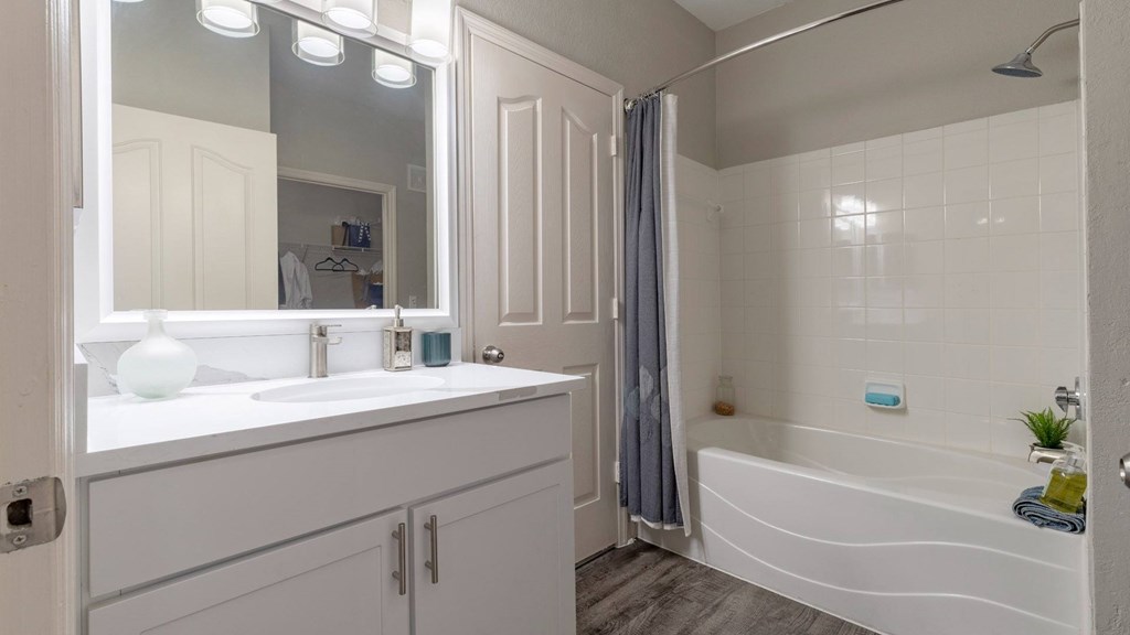 A white bathroom with a white sink and a white bathtub.