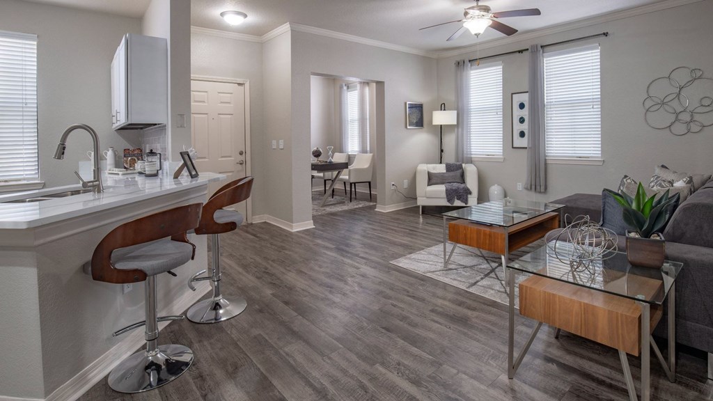 A modern kitchen with a bar stool and a dining table.