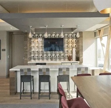 a kitchen with a bar and chairs and a television