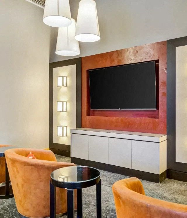 a living room with a tv and chairs and a table