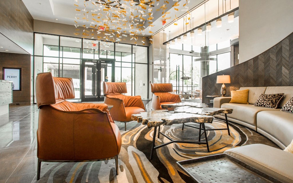 a lobby of a hotel with couches and chairs and a rug