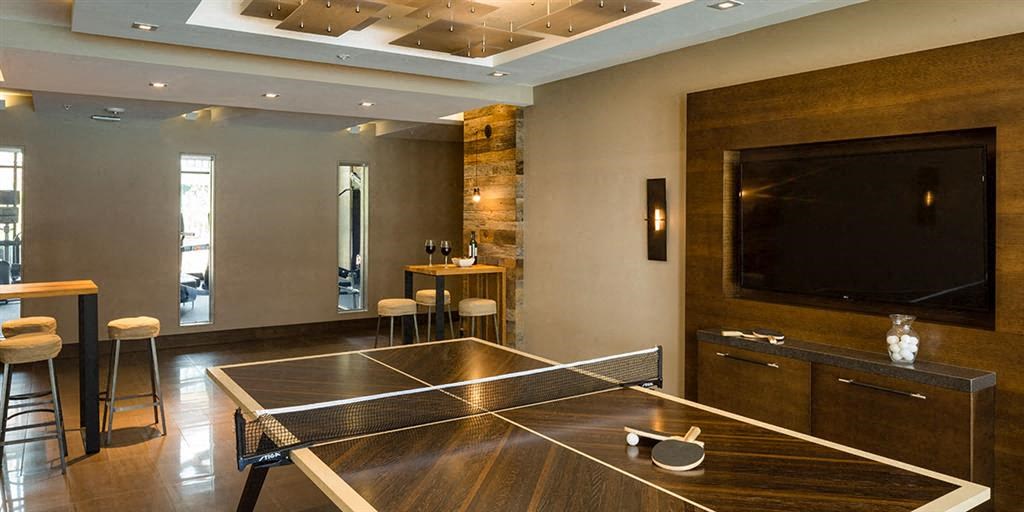a room with a ping pong table and a television