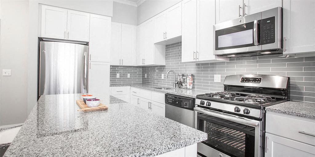 a kitchen with a marble counter top and a stove