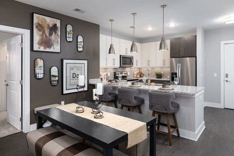 A kitchen with a table and chairs in front of it.