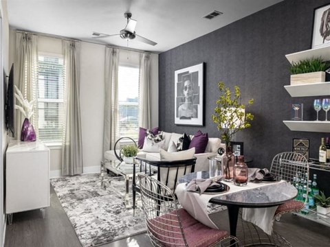 A living room with a dining table set up with chairs around it.