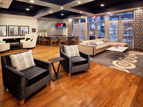 A living room with a black leather chair and a white sofa.
