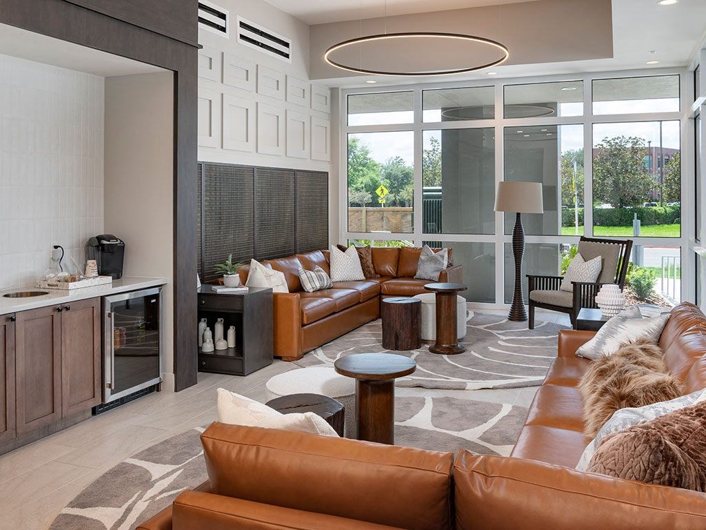 A modern living room with brown leather couches and a circular light fixture.
