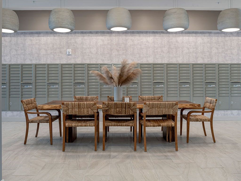 A dining table with chairs and a decorative plant in the middle.