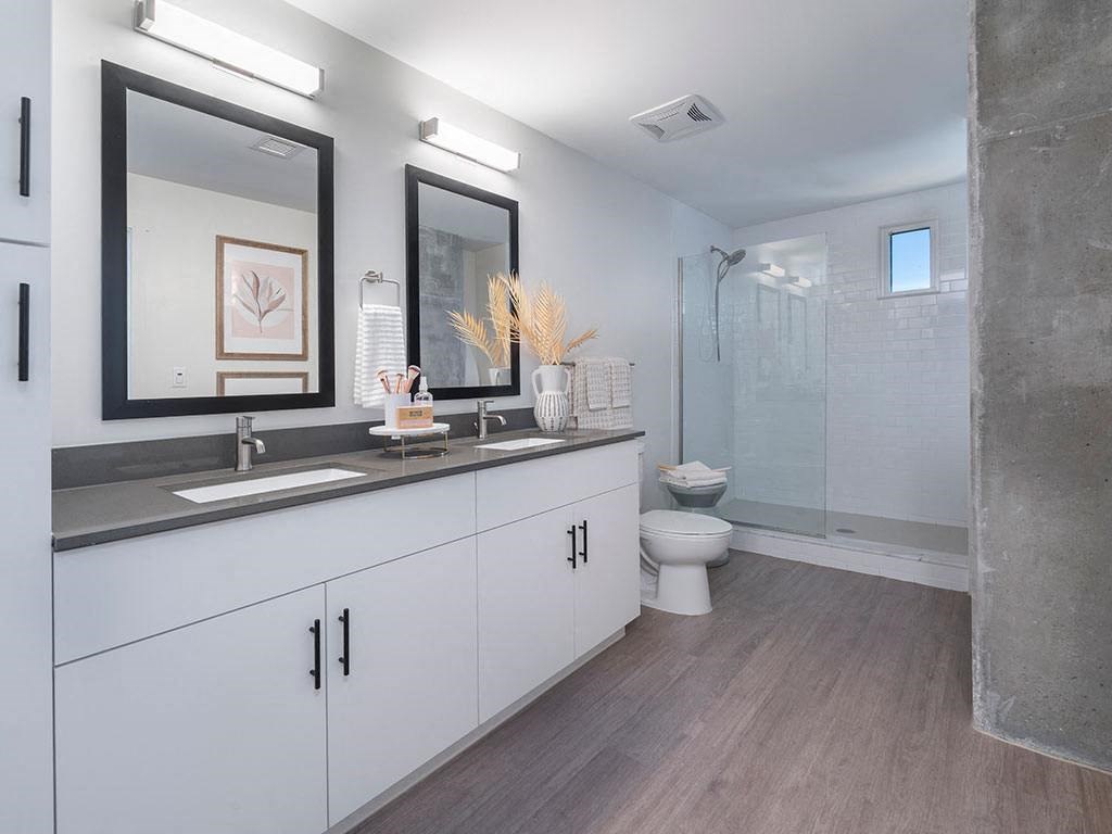 A modern bathroom with a white vanity and a walk-in shower.