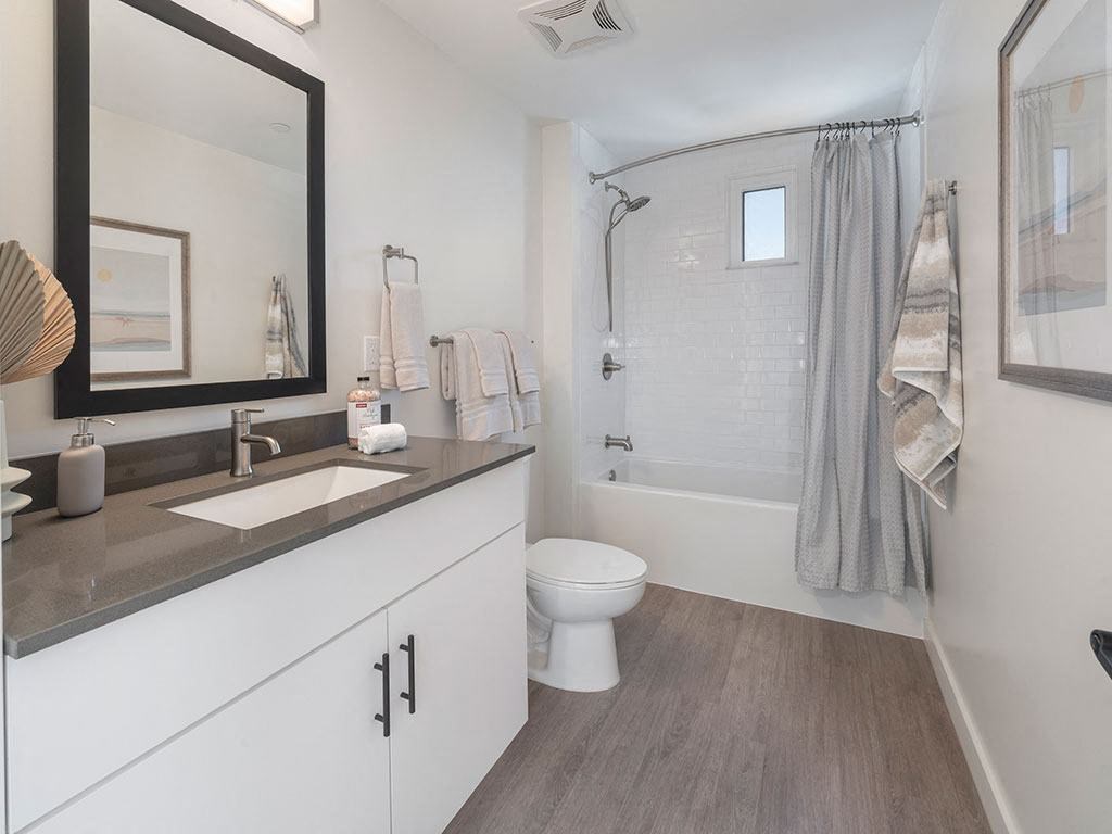A bathroom with a toilet, sink, and shower.