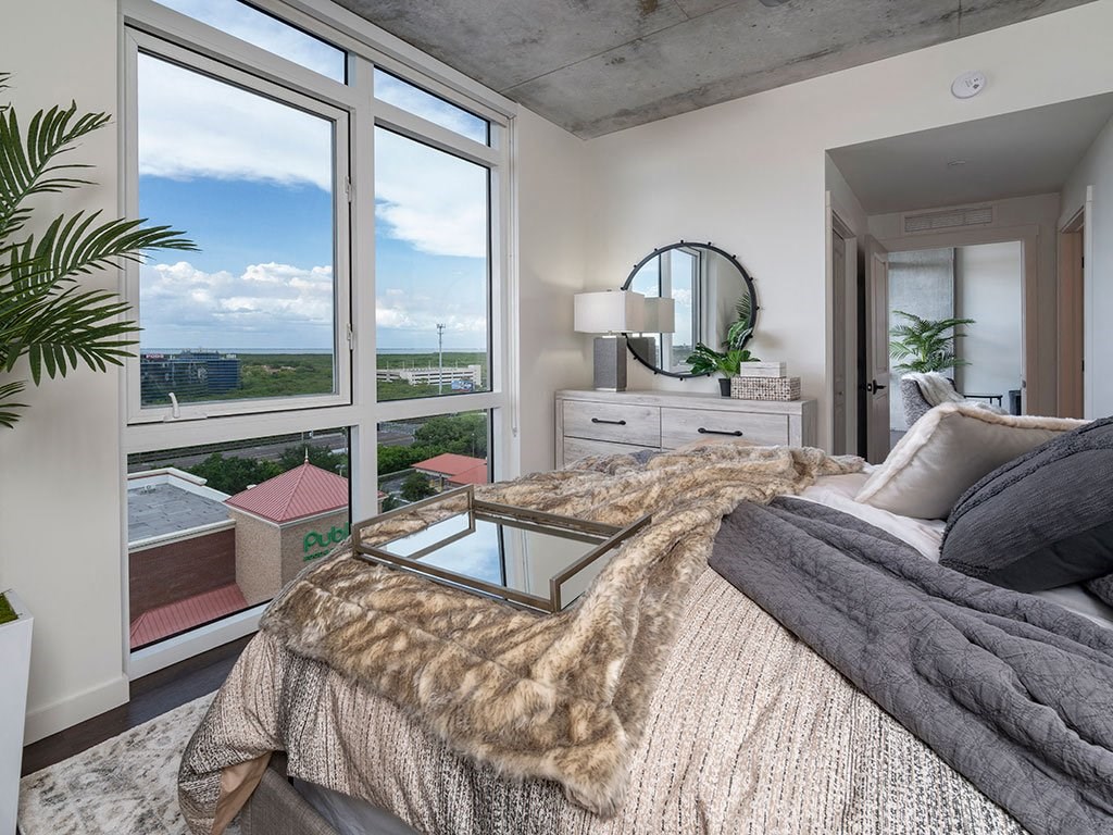 A bedroom with a large bed and a view of the city.