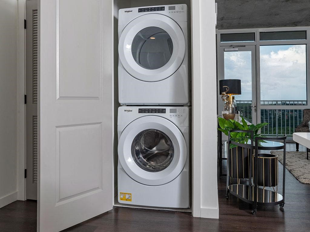 A modern laundry room with a washer and dryer stacked on top of each other.