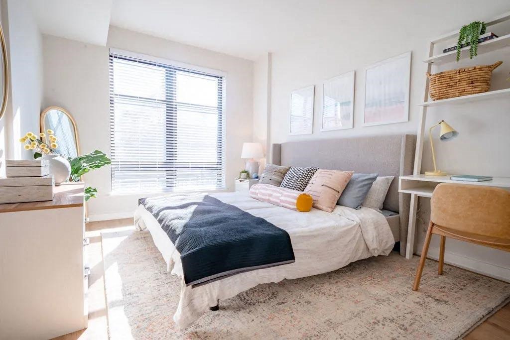 a bedroom with a bed and a desk and a window