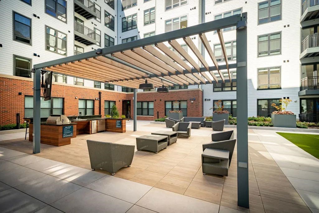 an outdoor patio with furniture and a large building