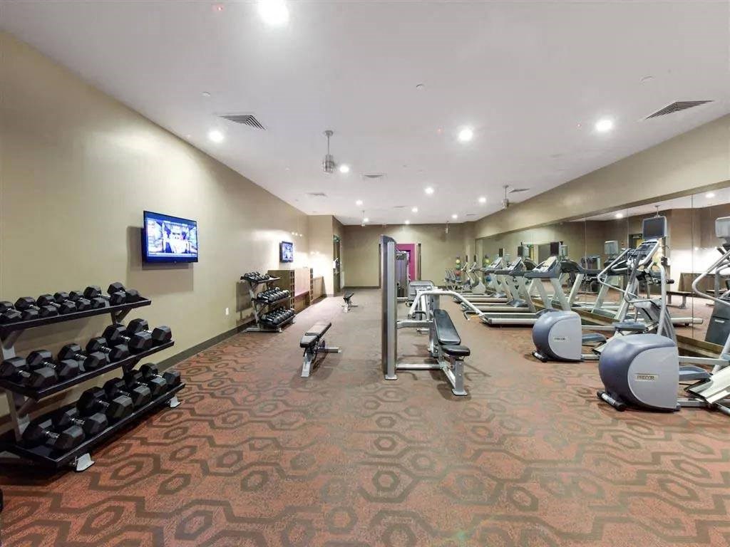 a gym with weights and a tv on the wall