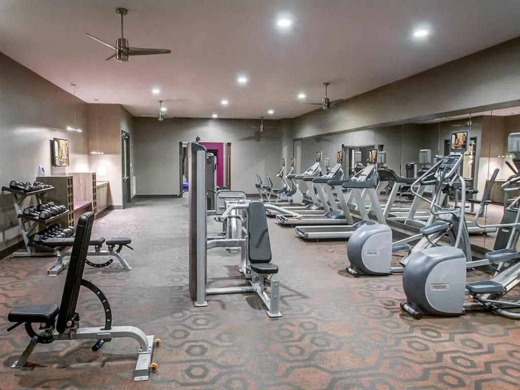 a gym with cardio equipment and weights on the floor
