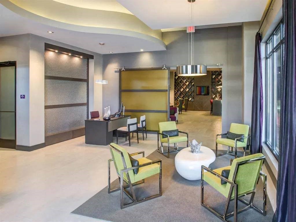 a lobby of a building with chairs and a table