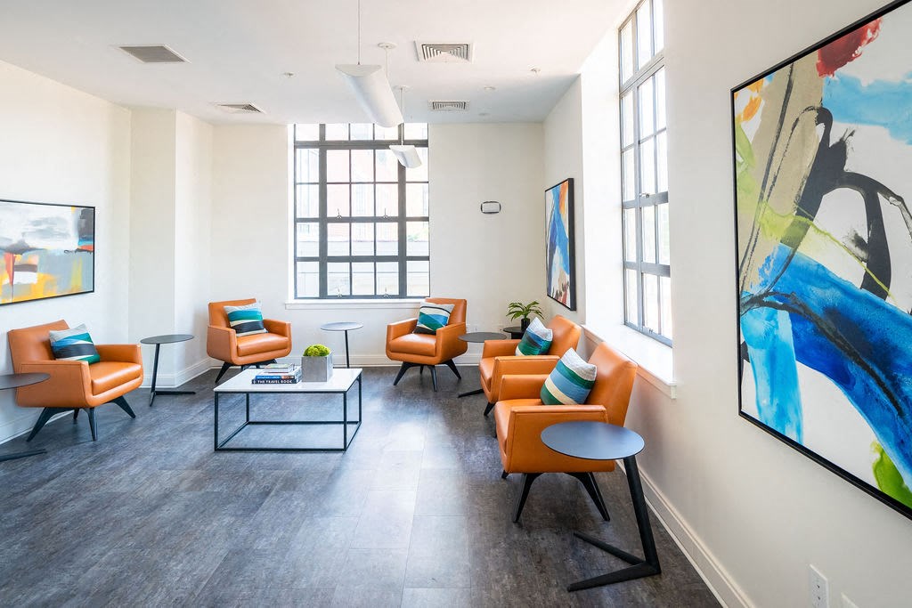 a living room with orange chairs and a table