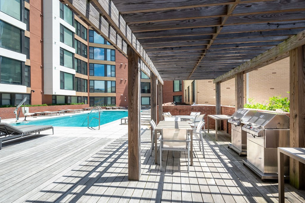 a patio with tables and chairs and a swimming pool