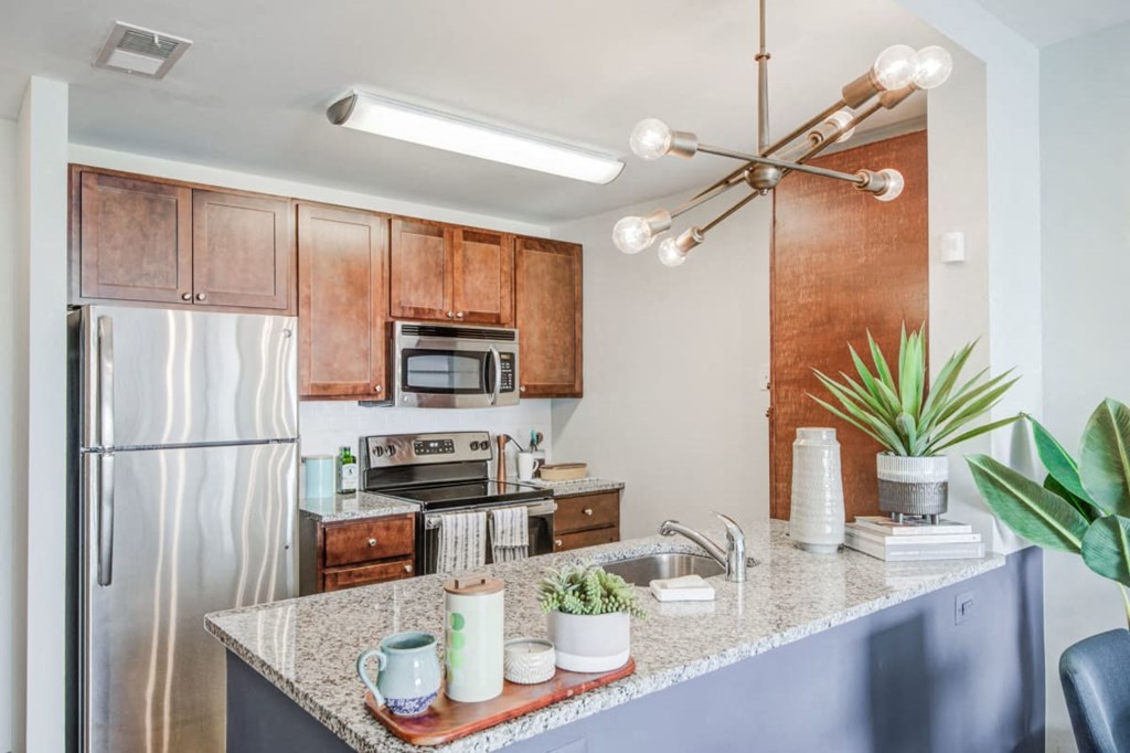 a kitchen with a granite counter top and a stainless steel refrigerator