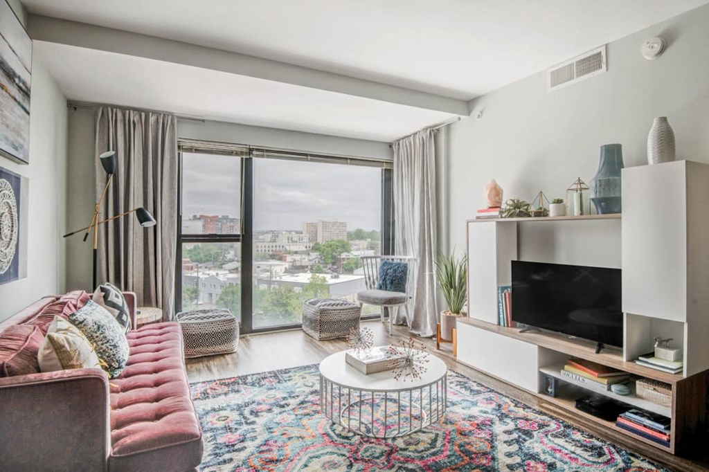 a living room with a couch and a tv and a window