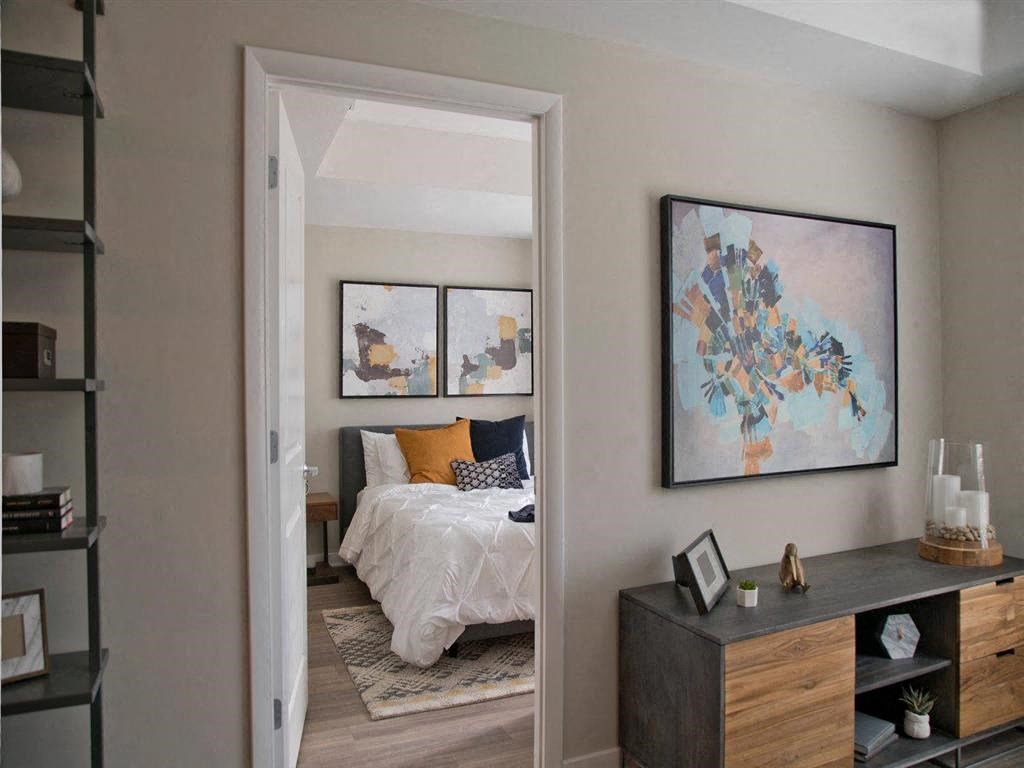 a bedroom with a bed and a painting on the wall