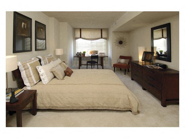 a bedroom with a large bed and a desk