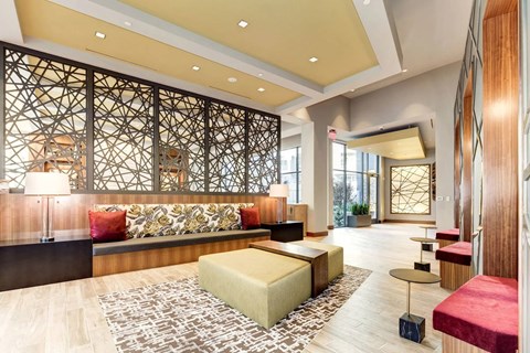 A modern living room with a large sectional sofa and a patterned rug.