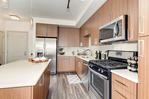 A modern kitchen with wooden cabinets and stainless steel appliances.