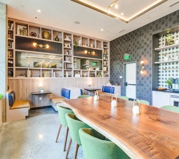 a dining room with a long wooden table and green chairs