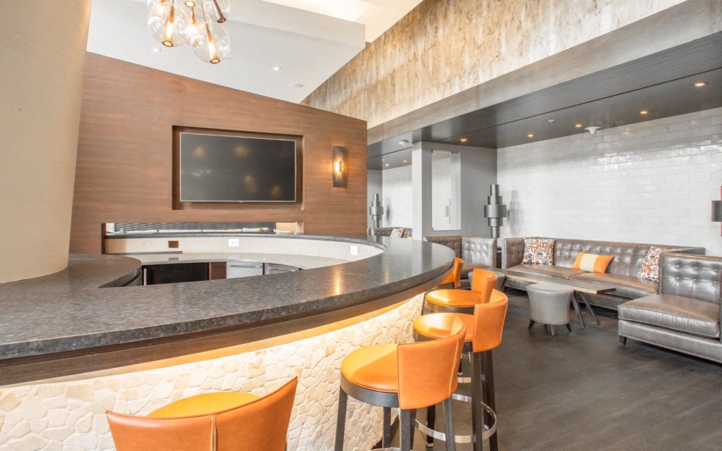 a lobby with a bar and chairs and a television