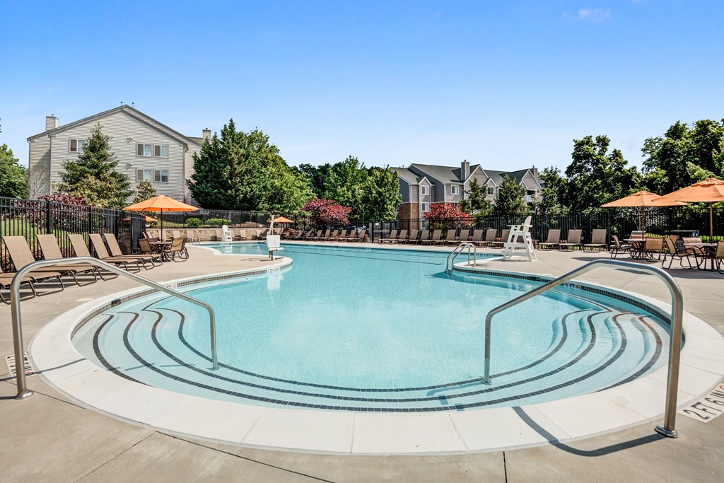 our apartments have a resort style pool with chairs and umbrellas