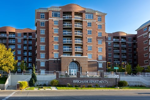A large red brick apartment building with the words Brigham Apartments on the front.