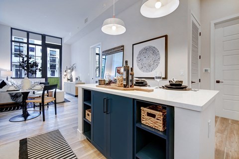 A kitchen with a white counter and blue cabinets.