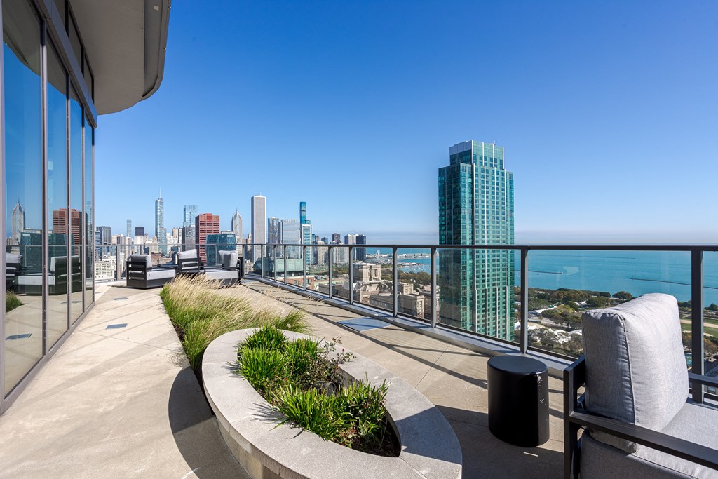 A balcony with a view of the city and the ocean.