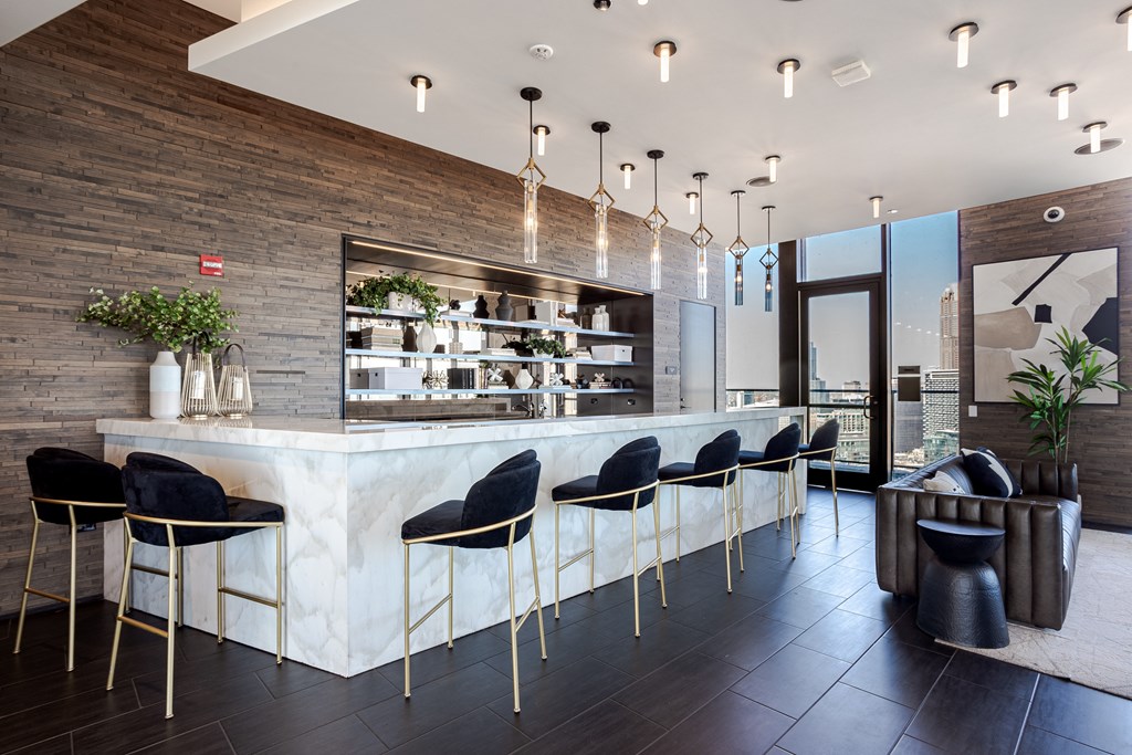 A modern bar with black chairs and a wooden wall.