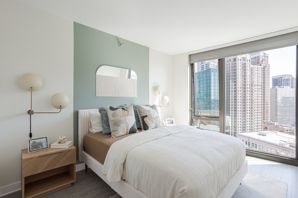 A bedroom with a large bed and a view of the city.