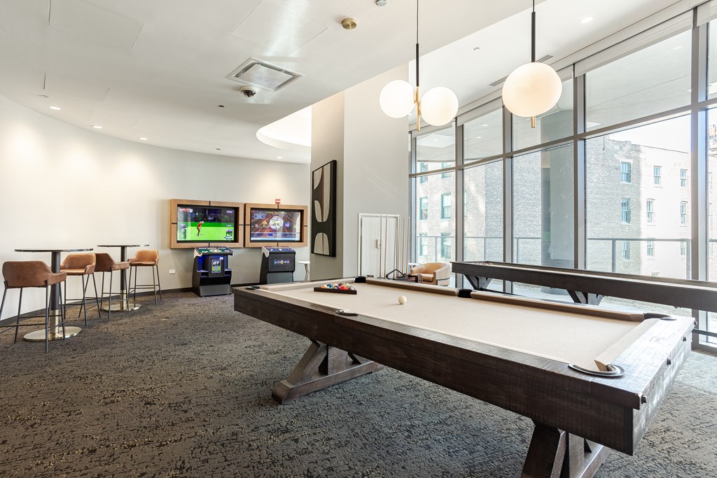 A room with a pool table and a television.