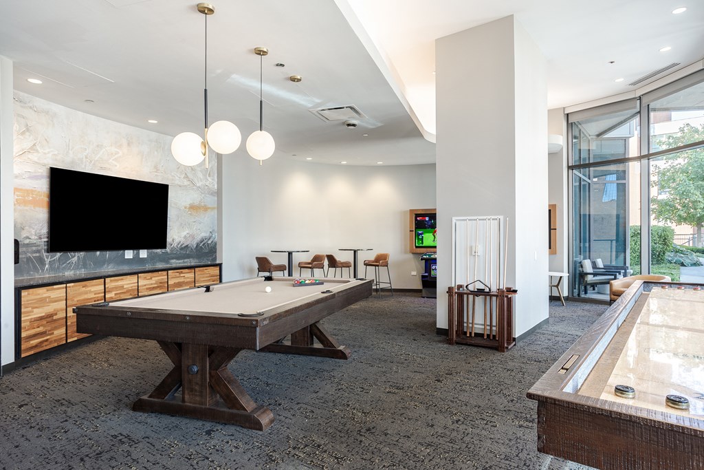 A room with a pool table and a tv.