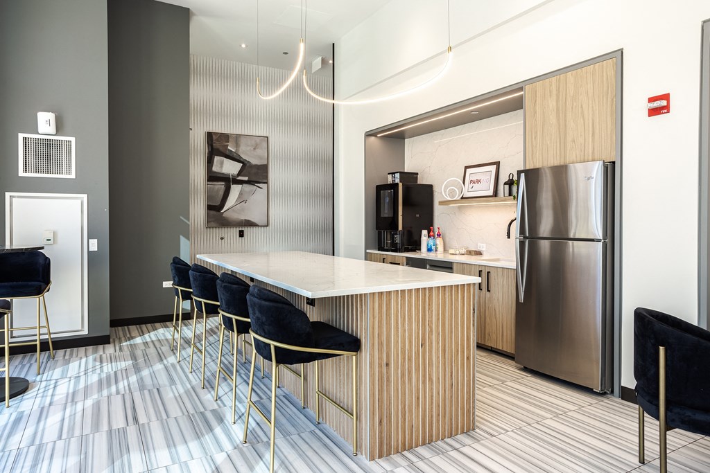 A modern kitchen with a bar area and a refrigerator.