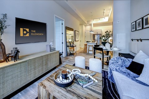 A living room with a sofa, a coffee table, and a painting on the wall.