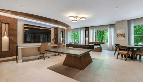 A modern living room with a large wooden coffee table and a flat screen TV.