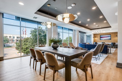a dining room with a table and chairs and a large window