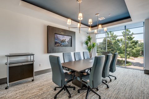a conference room with a long table and chairs and a window